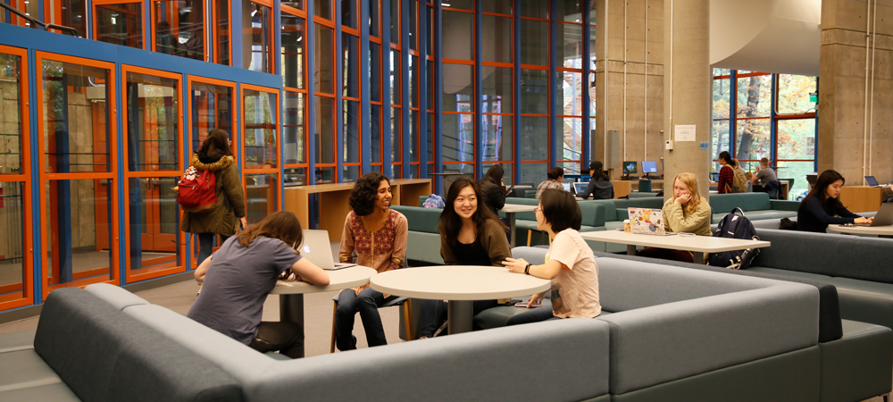 Students sitting in a common area at a table talking