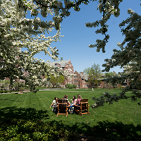 Students sitting in lawn chairs on a spring day